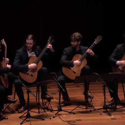 Four guitarists perform on stage